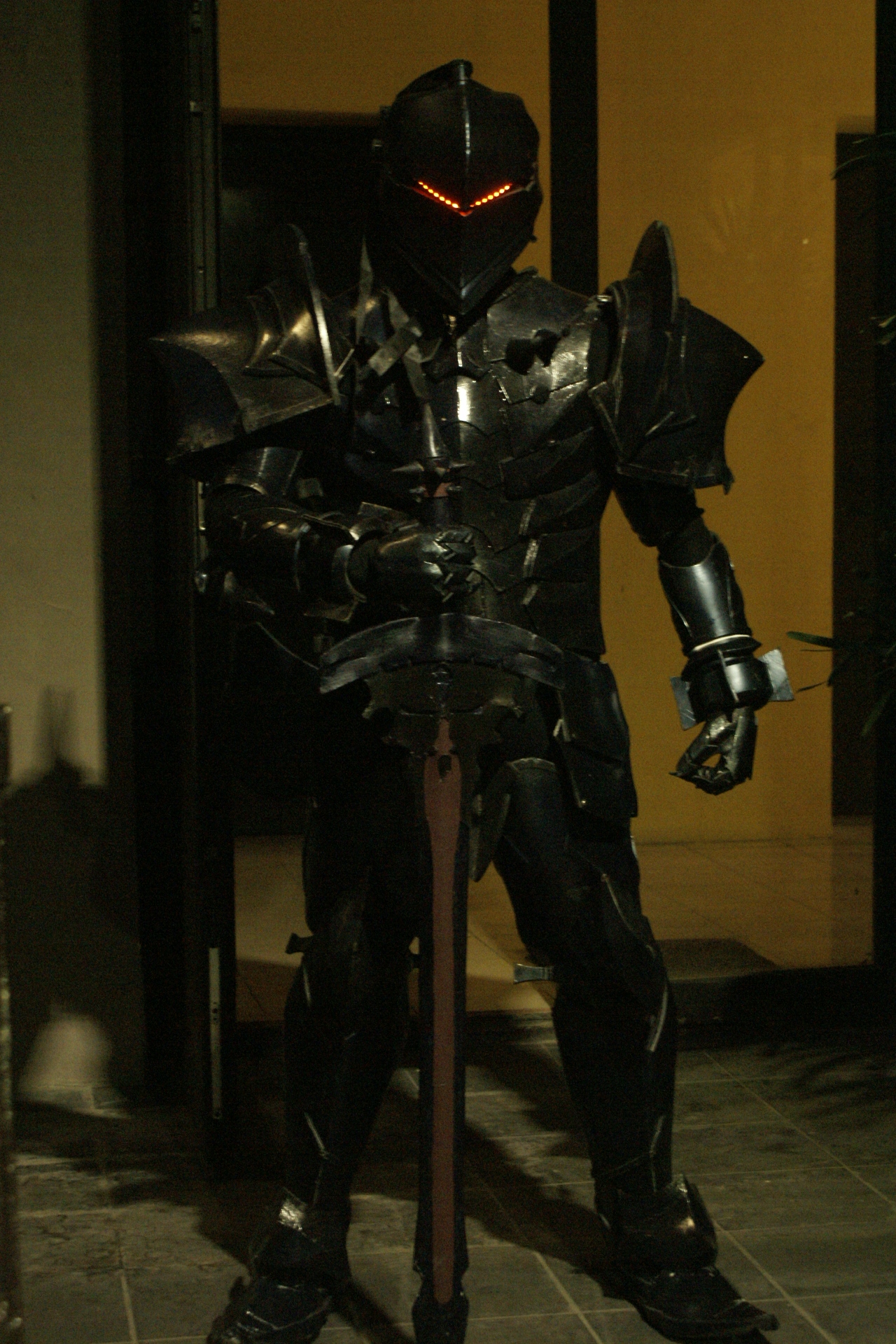 A dark, sharp-edged suit of armor with a sword and red lights for eyes.